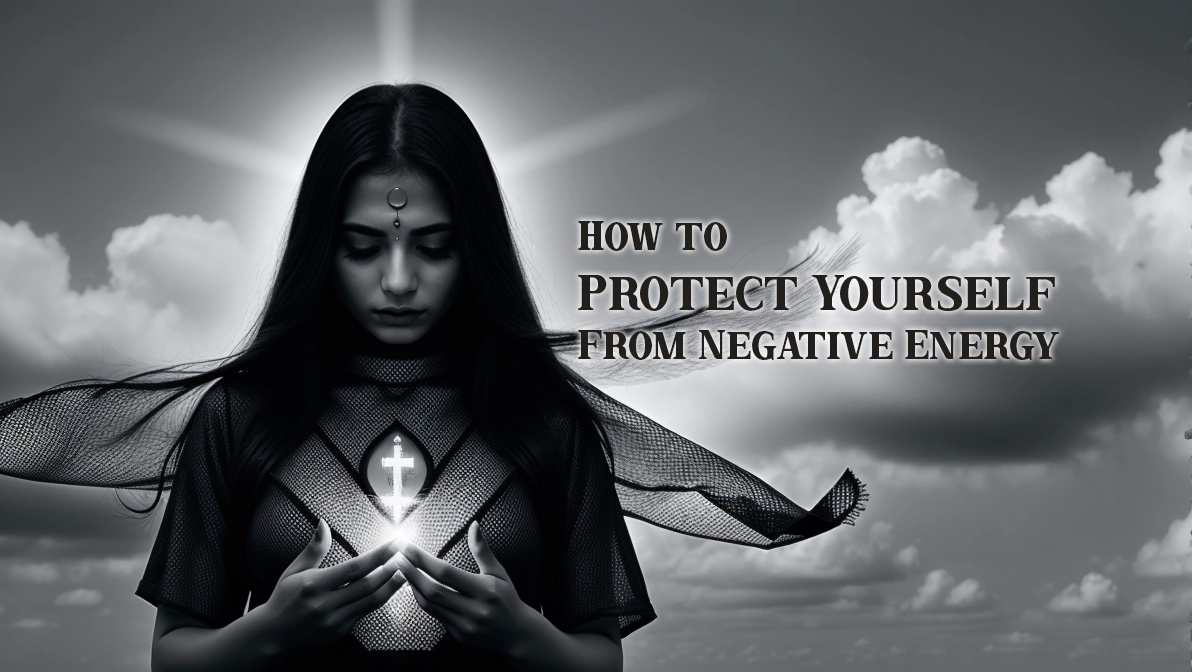 A mysterious woman dressed in dark spiritual attire stands against a cloudy sky, holding a glowing cross of light in her hands. She has a serene yet powerful expression, with a third-eye symbol on her forehead, symbolizing spiritual protection and energy shielding. The wind moves through her flowing cape, adding a mystical aura to the scene. The text beside her reads 'How to Protect Yourself from Negative Energy,' emphasizing the theme of spiritual defense.